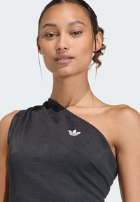 Czarny top na jedno ramię wykonany z gładkiego, błyszczącego materiału. Posiada subtelny wzór oraz biały logo Adidas na piersi.