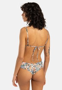 Kwiatowy bikini z wielokolorowym nadrukiem, regulowanymi ramiączkami i wiązaniem z tyłu; materiał wydaje się elastyczny i ma gładką fakturę.