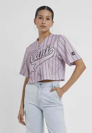 Tricou scurt, cu mânecă scurtă, de tip cropped, în nuanță de purpuriu deschis, cu dungi verticale negre și un grafic cu logo. Butoane pe partea din față, croi lejer.