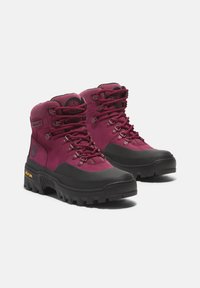 Bottes de randonnée bordeaux avec semelles et accents en caoutchouc noir, dotées d'œillets en métal, d'un col rembourré et de détails de logo sur les côtés.