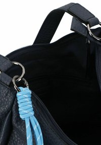 Marine faux leren tas met een gestructureerd oppervlak, zilverkleurige hardware en een blauwe koordaccent op de rits. Binnenkant is zwart en niet gevoerd.