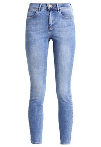 Jeans ajustados de color azul claro, hechos de denim, con una cintura alta, diseño clásico de cinco bolsillos y un leve desvanecimiento.
