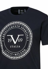 Navyblauwe katoenen T-shirt met een groot wit cirkelvormig logo met "V 1969" en decoratief kettingontwerp. Korte mouwen en ronde hals.