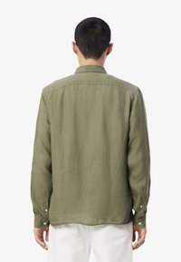 Groene, langmouwige shirt met een relaxte pasvorm, gemaakt van gestructureerde stof. Heeft een standaard kraag, knoopmanchetten en een rechte zoom.