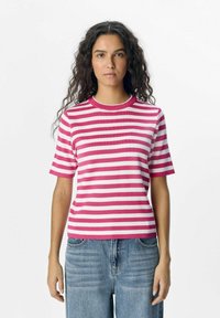 T-shirt à rayures à manches courtes en rose et blanc, texture côtelée, encolure ras du cou, coupe décontractée, associé à un jean bleu taille haute.