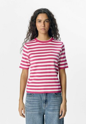 T-shirt à rayures à manches courtes en rose et blanc, texture côtelée, encolure ras du cou, coupe décontractée, associé à un jean bleu taille haute.