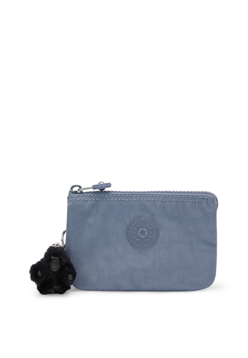 Ljusblå dragkedjefodral i mjukt tyg, med en rund logotyp och en svart fluffig apa nyckelring som accent. Kompakt och rektangulär form.