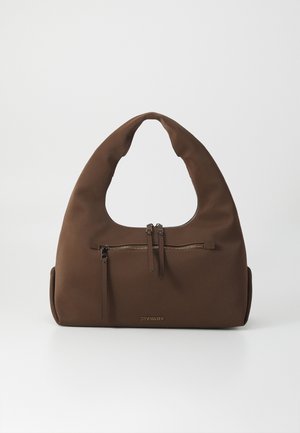 Brown fabric handbag with a unique curved handle and a zippered front pocket. Features a smooth texture and gold logo detail.