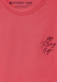 Korálová bavlněná tričko s krátkým rukávem, s kulatým výstřihem a černým grafickým potiskem palem a textem "Rising High."