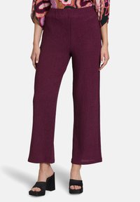 Pantalons larges texturés en couleur baies profondes avec une taille élastique. Assortis à des sandales à talons block noires.