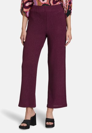 Pantaloni larghi e testurizzati di colore bacca profonda con vita elasticizzata. Abbinati a sandali neri con tacco a blocco.
