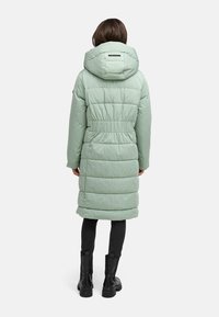 Lange, lichte mintgroene pufferjas met capuchon, elastische tailleband en zijzakken, met een horizontale quiltstructuur en zwarte accenten.