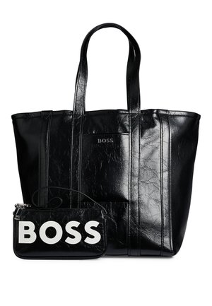 Bolso tote grande de cuero negro con dos asas y un bolsillo más pequeño en la parte delantera con la palabra BOSS en letras grandes y blancas.