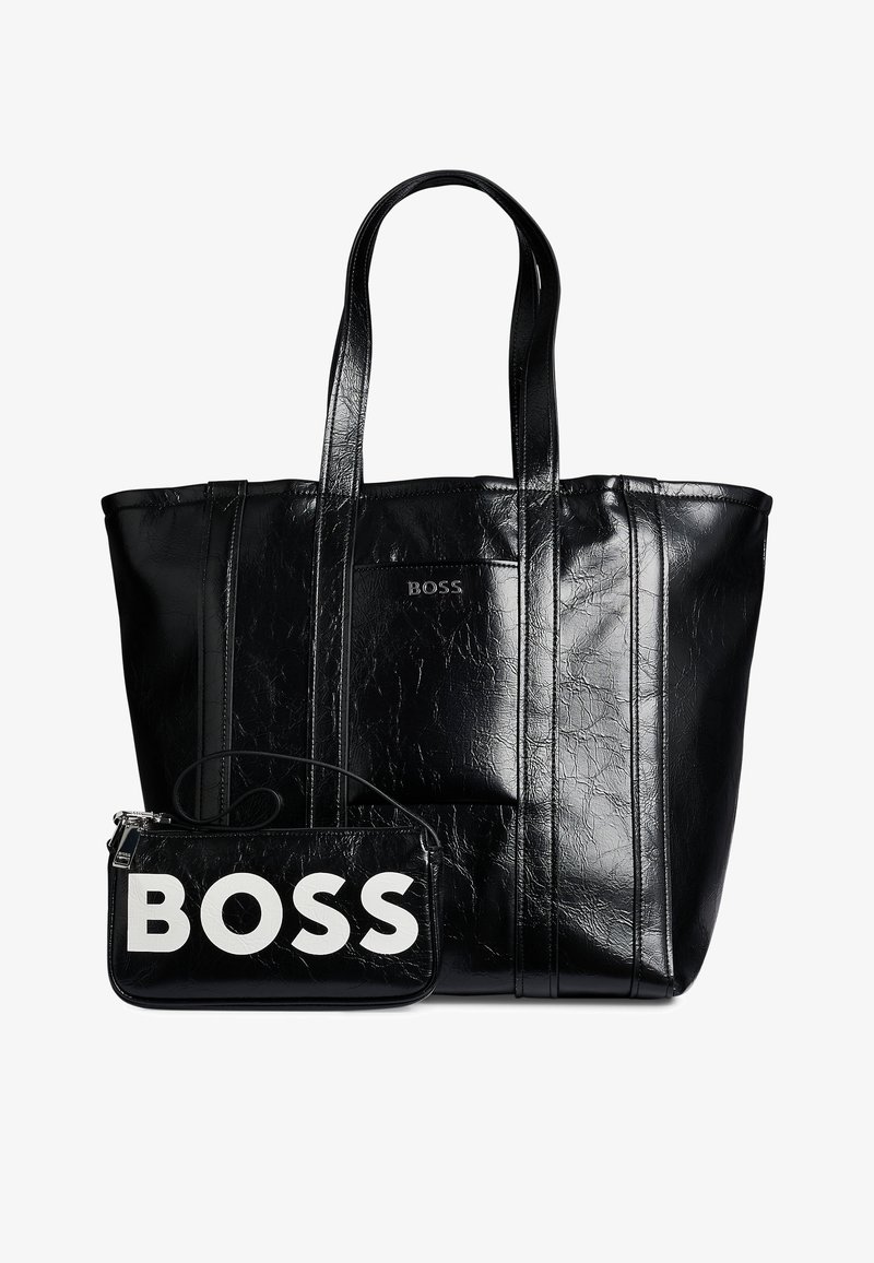 Grand sac cabas en cuir noir avec deux poignées et une petite pochette à l'avant avec le mot BOSS en grandes lettres blanches.