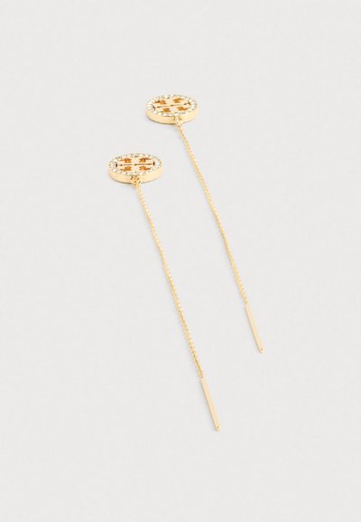 Χρυσά σκουλαρίκια με κυκλικό μενταγιόν που διαθέτει σχέδιο κοπής, διακοσμημένα με καθαρές πέτρες και κρεμασμένα με λεπτές αλυσίδες.