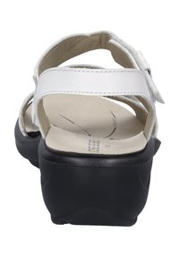 Białe skórzane sandały na platformie z czarną gumową podeszwą, z regulowanymi paskami i wyściełaną wkładką dla komfortu.