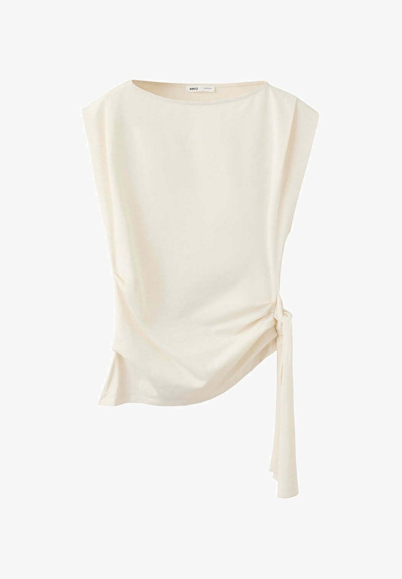 Blouse blanche sans manches avec col rond et détail noué sur le côté créant un effet froncé d'un côté.