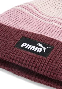 Gebreide beanie met een gradient van roze en bordeauxrood, met een textuurpatroon en een zwart PUMA-logo label op de omgeslagen rand.