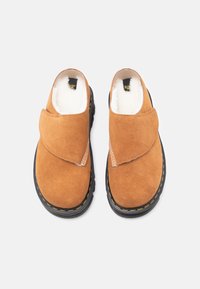Hnědé semišové slip-on boty s měkkou vnitřní podšívkou, zaoblenou špičkou a černou gumovou podrážkou s žlutými prošitími.