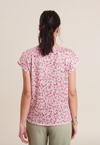 Kurzärmliges, blumengeprintetes Oberteil in Rosa-, Grün- und Beigetönen; aus weichem Stoff, mit abgerundetem Saum und lockerer Passform.