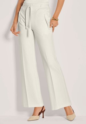 Weit geschnittene Hosen aus hellem Creme-Stoff, mit elastischem Bund, Kordelzug und Seitentaschen, kombiniert mit einem Slingback-Absatz.