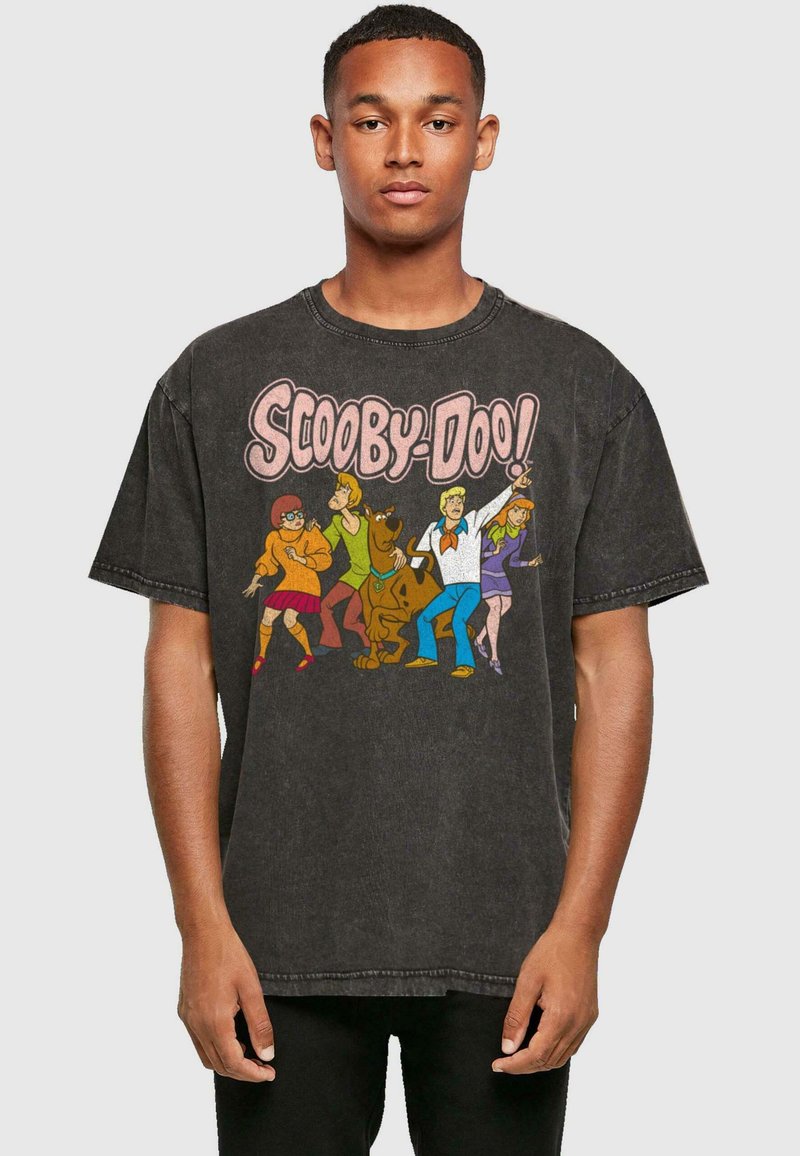 Camiseta negra de corte oversize hecha de algodón con una impresión gráfica de los personajes de Scooby-Doo en colores brillantes en el frente.