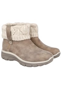 Botas de ante marrón claro hasta el tobillo con un puño de punto crema que presenta un patrón texturizado, puntera redondeada y suela de goma acolchada.