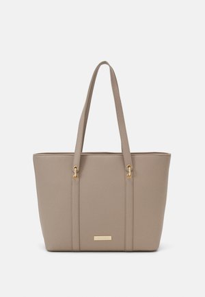 Beige Tasche aus Kunstleder mit zwei langen Griffen, goldenen Hardwareakzenten und einer strukturierten Oberfläche. Offenes Design mit minimaler Verzierung.
