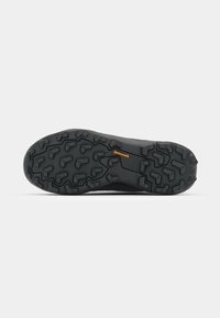 Schwarze Wanderstiefel-Sohle mit einem robusten, multidirektionalen Profildesign für Traktion, mit einem orangefarbenen Continental-Logo an der Seite.