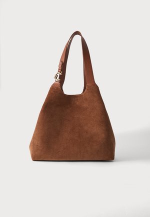 Sac cabas en velours côtelé marron avec bandoulière en cuir et ferrures dorées, debout sur un fond blanc uni.
