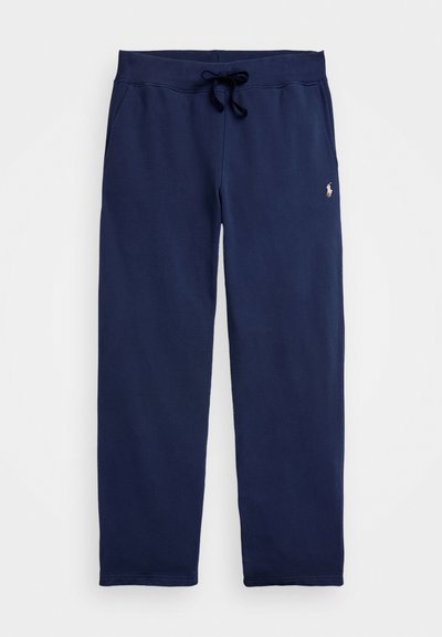 Marineblå joggebukser med elastisk midje og snor, sidelommer og liten brodert logo på høyre lår.