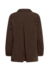 Chemise marron foncé à manches longues avec une ouverture centrale dans le dos et des poignets boutonnés, vue de dos sur fond blanc.