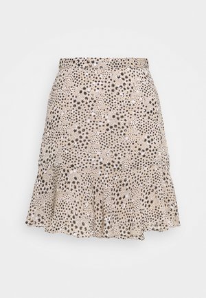 Jupe évasée beige avec une ceinture élastique et un motif d'étoiles noires dispersé sur tout le tissu.