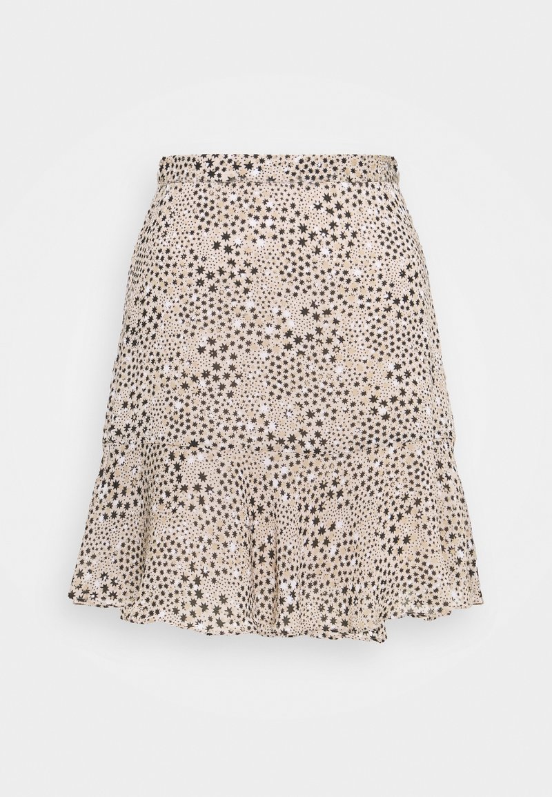 Beige uitlopende rok met een elastische tailleband en een zwart sterrenpatroon verspreid over de stof.