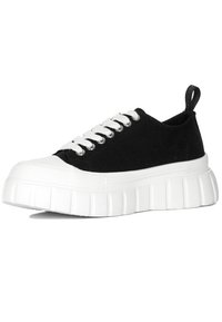 Sneaker nera in tela con suola in gomma bianca, punta rotonda e suola spessa e zigrinata. Presenta lacci bianchi e un anello sul retro per indossarla facilmente.