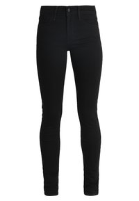 Jeans skinny negros, hechos de mezclilla; cuentan con una cintura alta, cinco bolsillos y una textura suave. El diseño es ceñido a lo largo de las piernas.