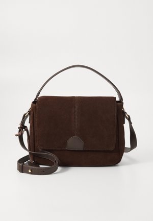 Bolso de gamuza marrón oscuro con asa superior y correa de hombro ajustable, que presenta una solapa frontal con cierre de lengüeta de cuero.