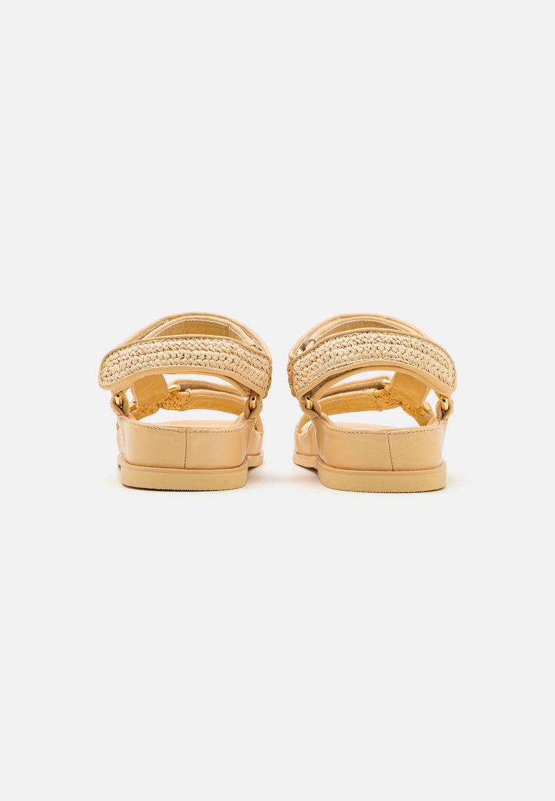 Braune Sandalen mit geflochtenen Riemen und einer glatten Sohle. Mit verstellbaren Schnallen und einem minimalistischen Stil gestaltet.