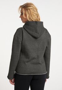 Mørkegrå hoodie med en blød tekstur, en tætsiddende design og en stor hætte. Har syet kant og lange ærmer. Bagens udsigt vises.