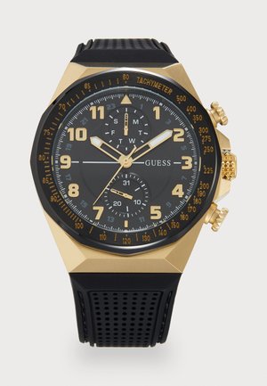 Black rubber strap watch with a gold-tone octagonal case. Black dial features gold markers, chronograph subdials, and tachymeter scale.