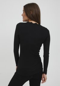 Zwarte longsleeve top van ribstof, met een geschulpte halslijn en zoom. Glad materiaal met een aansluitend ontwerp en geen zichtbare hardware.