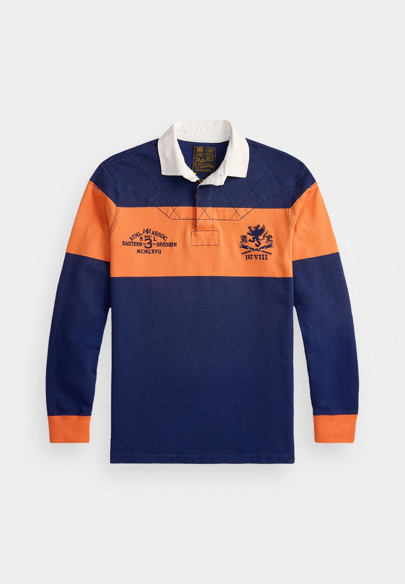 Tumesleeve polo särk, mis on valmistatud tumesinisest ja oranžist puuvillast, valge krae, diagonaalsed koloriblockid, tikitud muster ja tikkimisega detailid.
