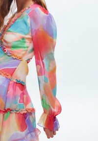 Durchsichtiges, mehrfarbiges Kleid mit Rüschendetails, das lebendige Aquarellmuster und lange, puffärmelige Ärmel mit ausladenden Manschetten aufweist.