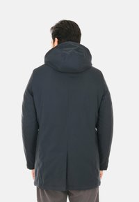 Parka isolante blu navy con cappuccio, caratterizzata da una superficie liscia, maniche lunghe e uno schienale ventilato per una migliore traspirabilità.