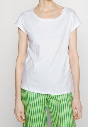 T-shirt blanc à manches courtes avec un large col, en tissu de coton lisse, associé à un pantalon rayé vert et blanc.