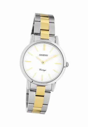 Montre argentée et dorée avec un cadran blanc, des marqueurs d'heure jaunes et des aiguilles délicates. Bracelet en acier inoxydable avec des maillons dorés alternés.