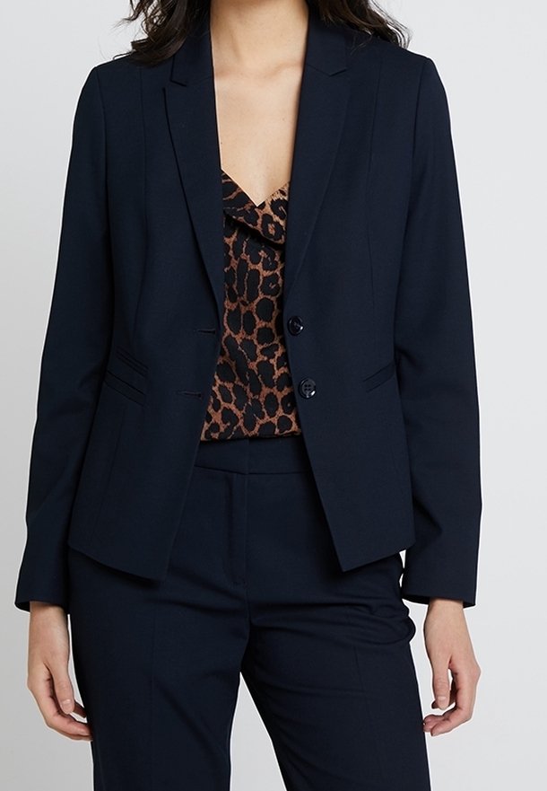 Marinblazer med en skräddarsydd passform, slagkrage, två knappar, sidfickor och balanserad sömnad. Kombination med en topp i leopardmönster.