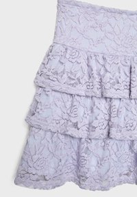 Lavanda čipkasta suknja s tri sloja, s cvjetnim uzorkom i teksturiranim završetkom. Elastična traka u struku za udobno nošenje.
