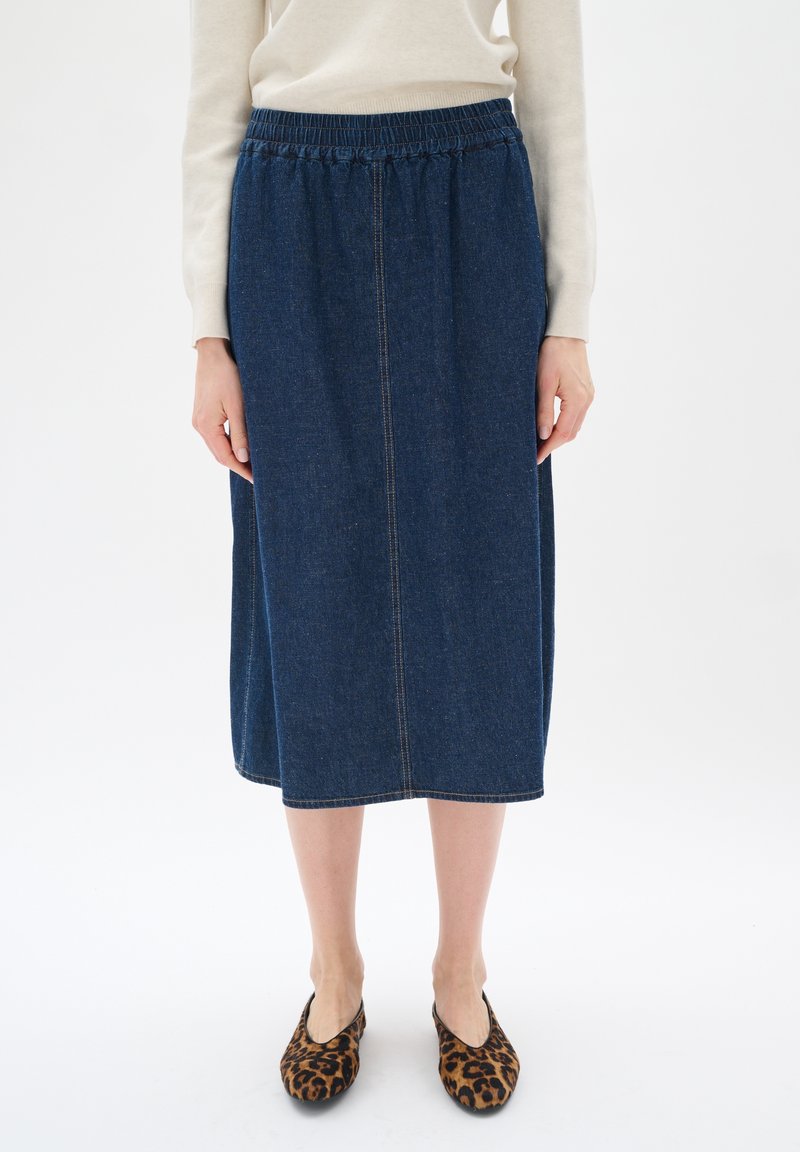 Denim midi sukně s elastickým pasem, tmavě modré barvy a rovnou siluetou. Stylová s leopardími baleríny a lehkým svetrem.