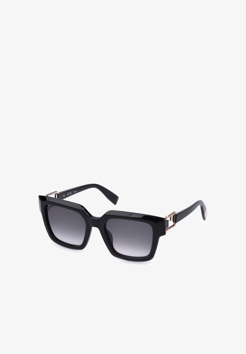 Lunettes de soleil noires carrées oversize avec verres dégradés foncés et accents métalliques dorés sur les branches.